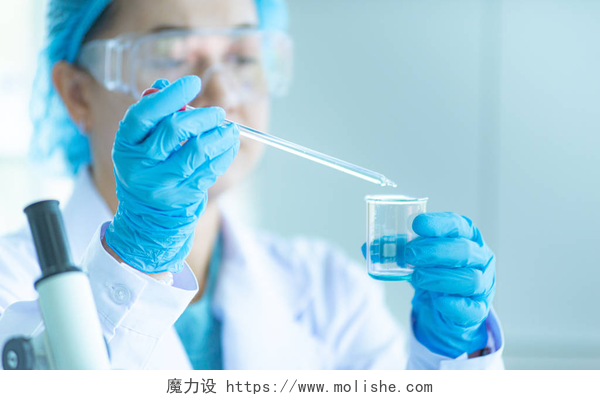 在实验室里用器皿进行检测的研究员亚洲女科学家、研究员、技术员或学生使用显微镜进行研究或实验,显微镜是医学、化学或生物实验室的科学设备